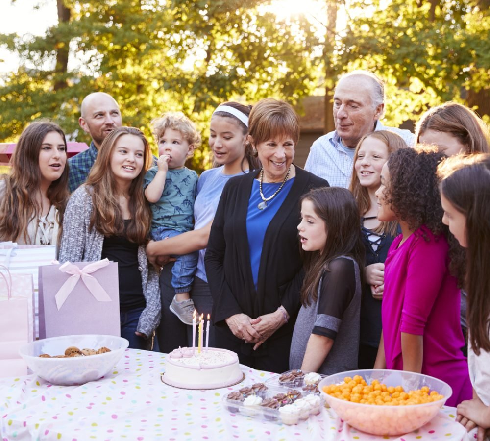 Friends and family gathered in a garden for a birthday party